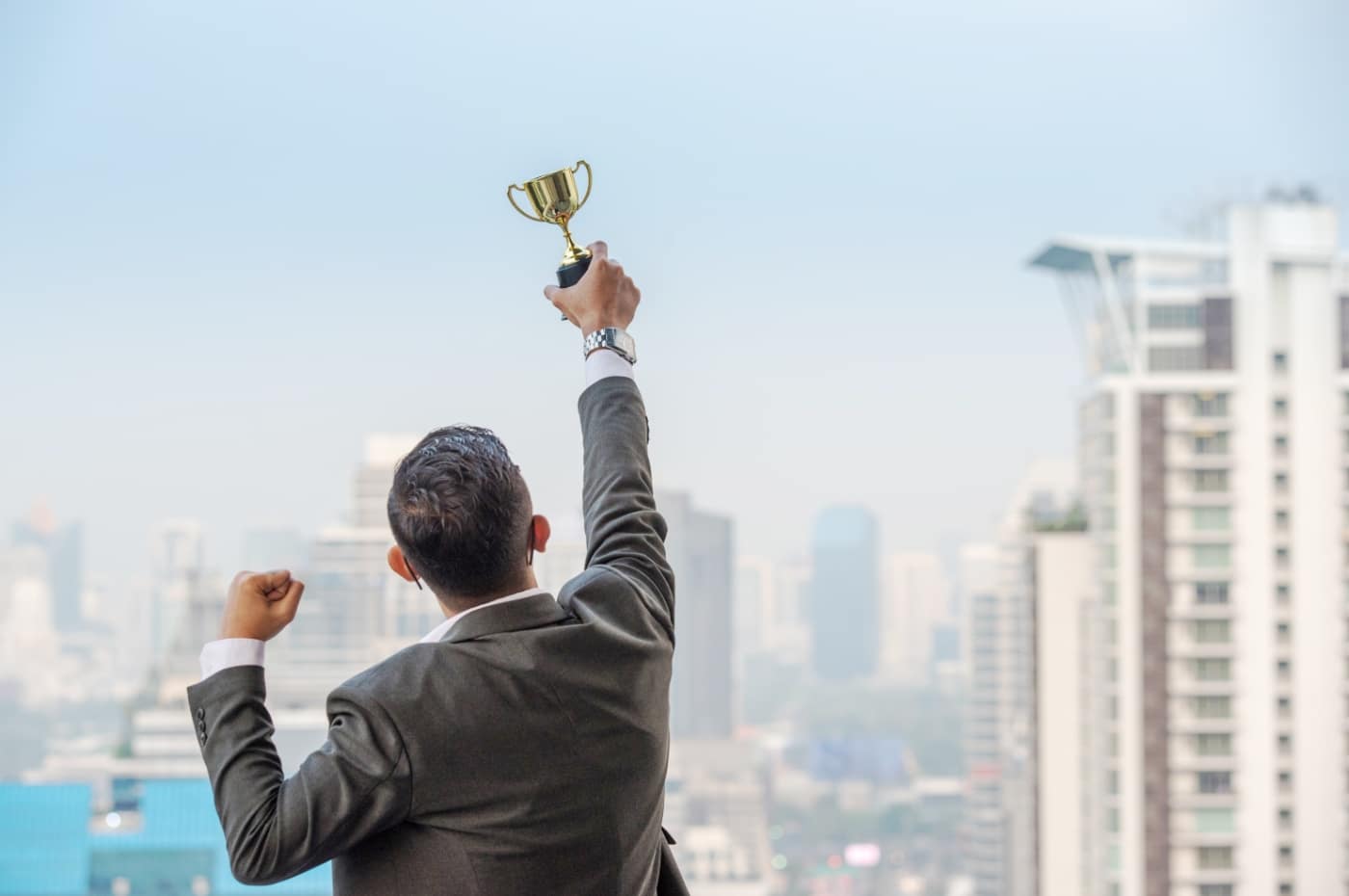 businessman-celebrating-with-trophy